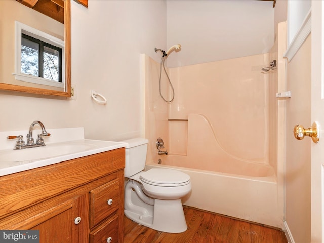 full bath featuring toilet, shower / bathtub combination, wood finished floors, and vanity