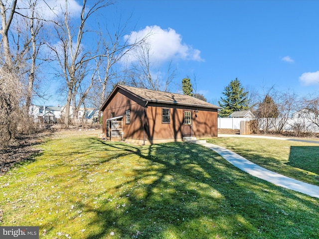 rear view of property featuring fence and a lawn