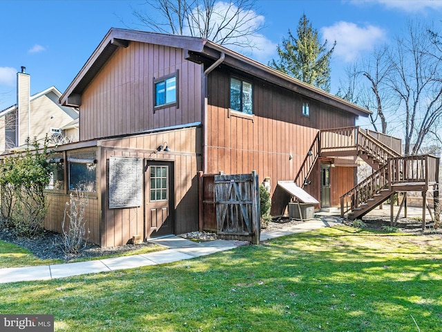 rear view of house featuring central AC, a yard, and stairs