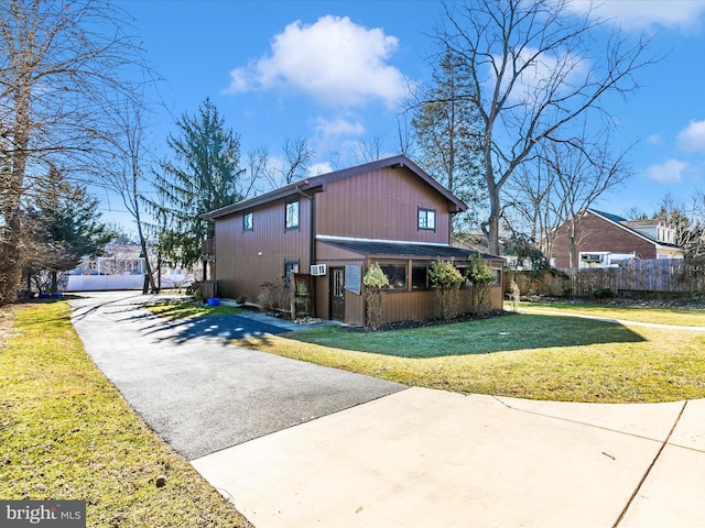 view of property exterior featuring a yard and fence