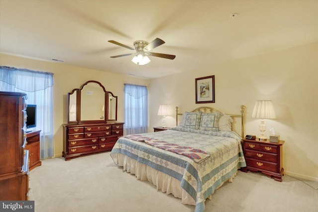 bedroom featuring light carpet, baseboards, visible vents, and a ceiling fan