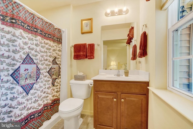 bathroom featuring curtained shower, vanity, and toilet