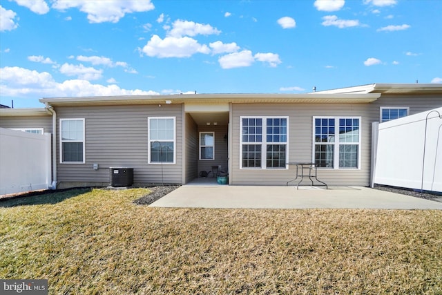 rear view of house with central air condition unit, a patio area, fence, and a lawn