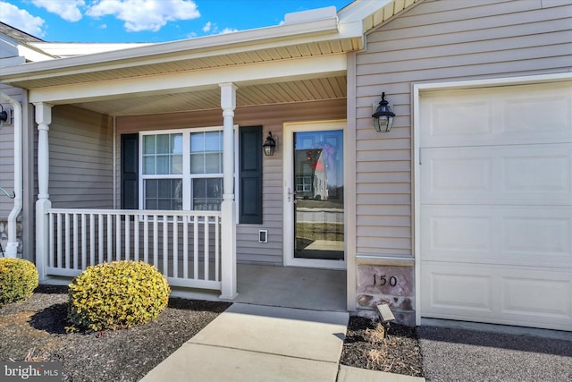 property entrance featuring covered porch and a garage