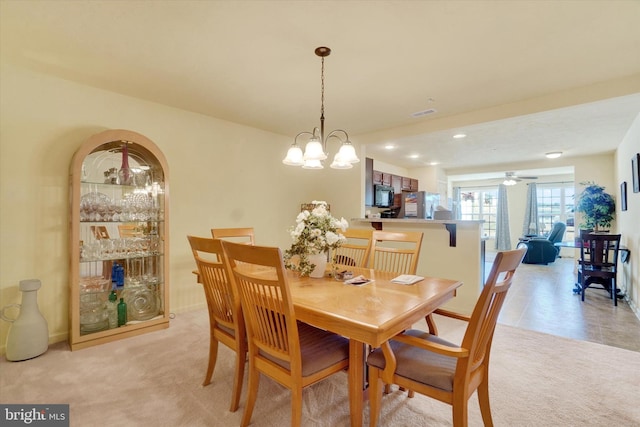 dining area with light carpet and an inviting chandelier