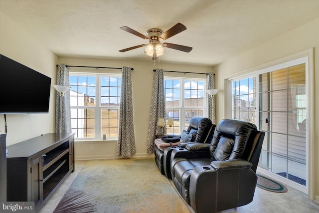 sitting room with ceiling fan and baseboards