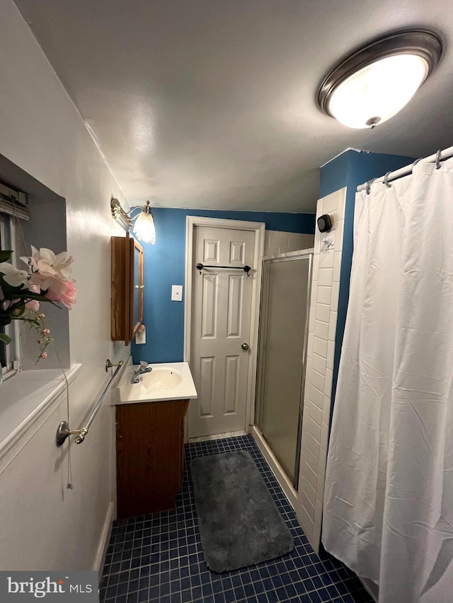 full bath with a stall shower, vanity, and tile patterned floors