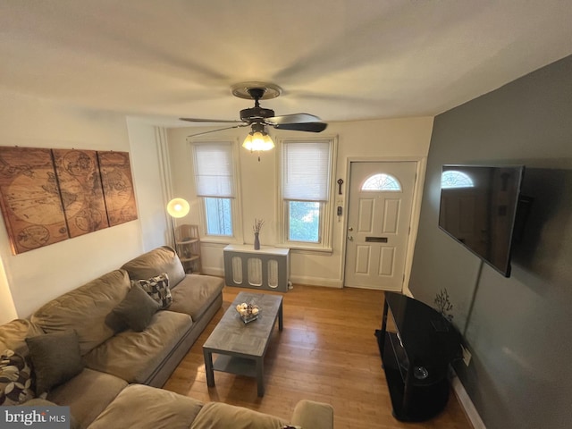 living area with ceiling fan, wood finished floors, and baseboards