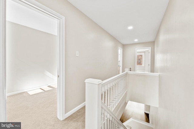 hallway with recessed lighting, baseboards, carpet flooring, and an upstairs landing