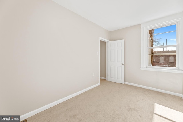 carpeted empty room featuring baseboards