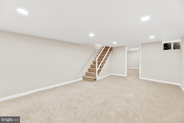 finished basement with recessed lighting, light carpet, stairway, and baseboards