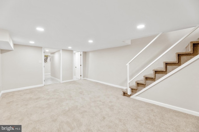 finished basement featuring stairway, carpet, baseboards, and recessed lighting