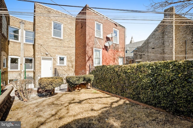 rear view of property featuring brick siding