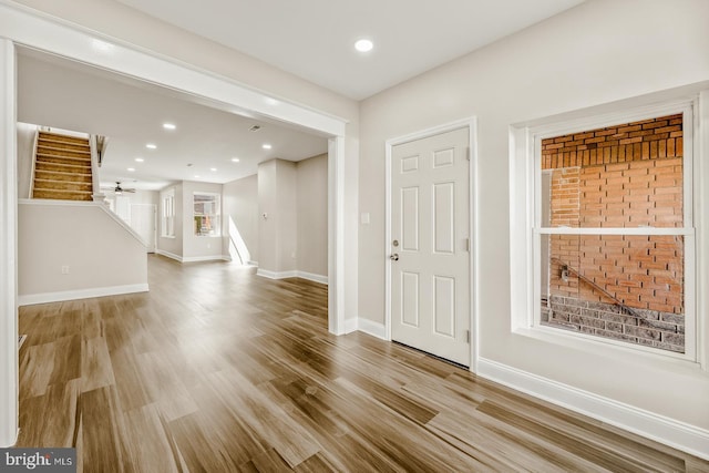 foyer entrance featuring stairs, baseboards, and wood finished floors