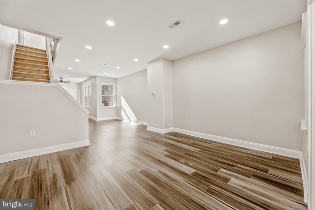 spare room with baseboards, visible vents, wood finished floors, stairs, and recessed lighting