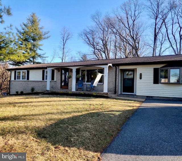 single story home with crawl space, brick siding, a porch, and a front yard