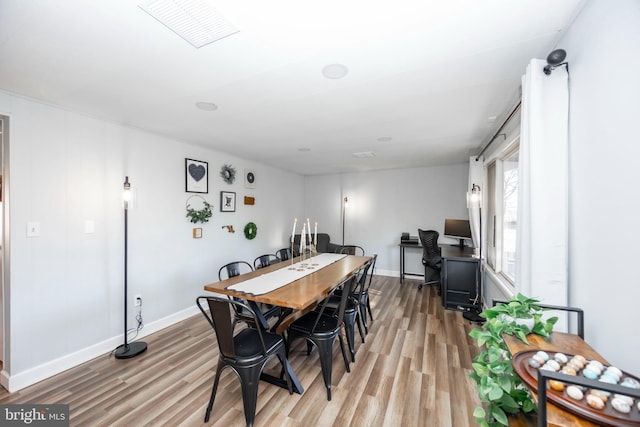 dining area with visible vents, wood finished floors, and baseboards