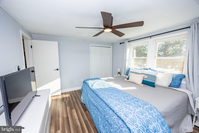 bedroom featuring a closet, baseboards, wood finished floors, and a ceiling fan