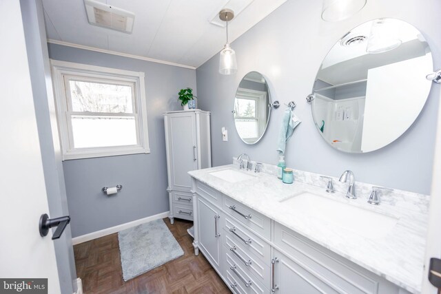 bathroom featuring double vanity, visible vents, baseboards, and a sink