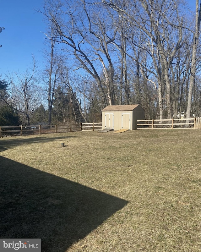 view of yard with a storage unit, a fenced backyard, and an outdoor structure