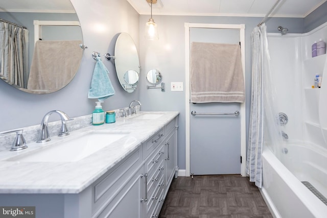 full bath featuring double vanity, shower / tub combo with curtain, crown molding, and a sink