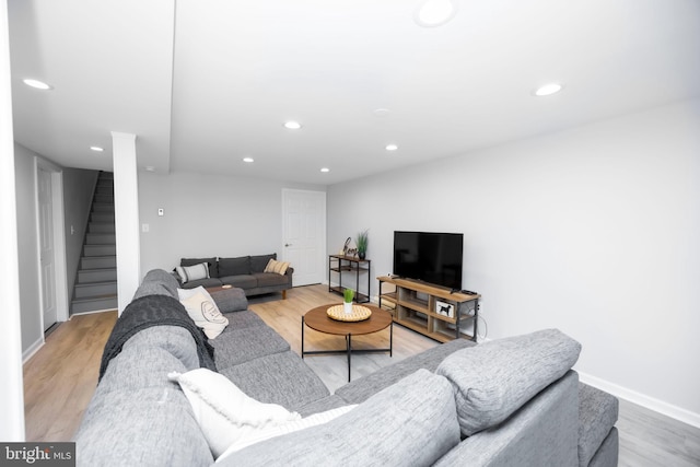 living area featuring recessed lighting, baseboards, stairs, and light wood-style floors