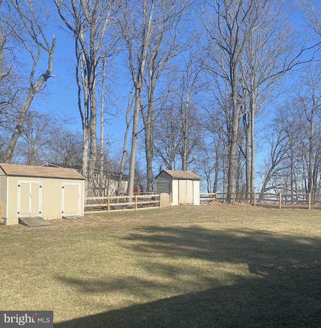 view of yard with an outbuilding, a storage shed, and a fenced backyard