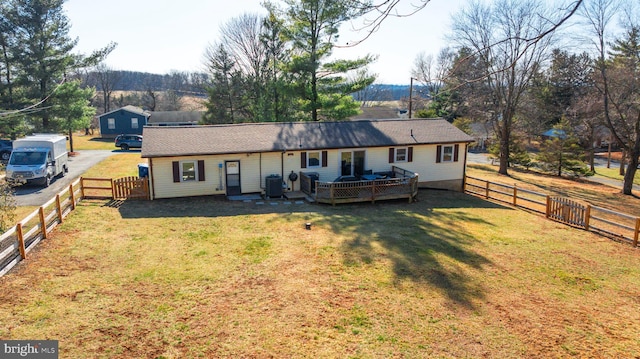 back of house with central air condition unit, a lawn, a fenced backyard, and a deck