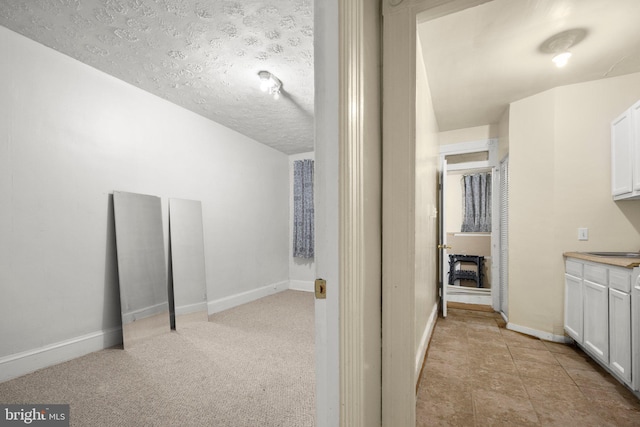 bathroom with a textured ceiling and baseboards