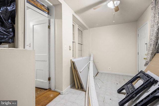 washroom with baseboards, ceiling fan, and light floors