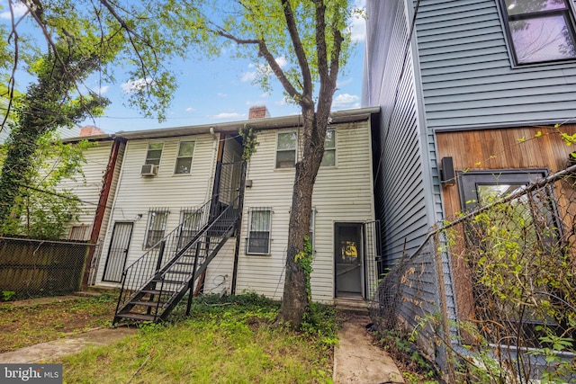 view of front of home featuring stairway, fence, and a chimney