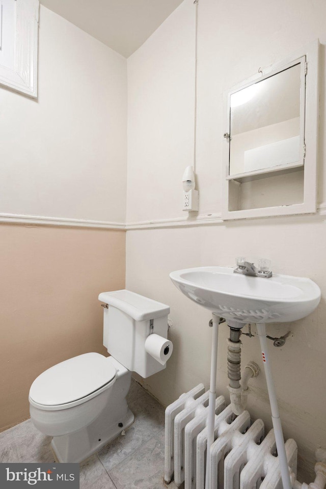 bathroom featuring radiator and toilet