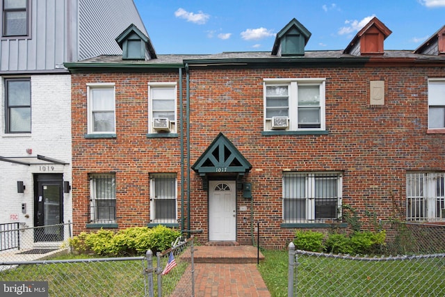 townhome / multi-family property with brick siding and a fenced front yard