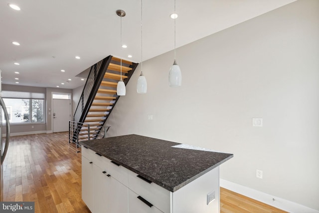 kitchen featuring white cabinets, recessed lighting, light wood finished floors, and a kitchen island