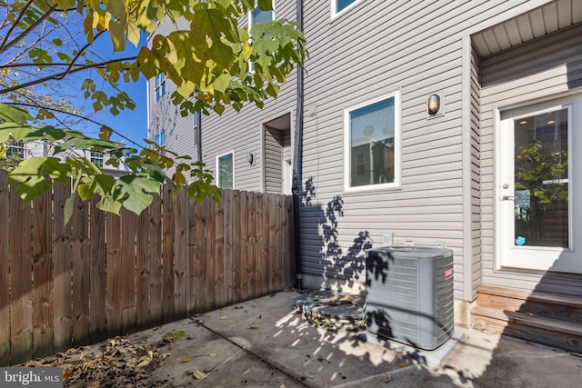 view of patio featuring central AC unit and fence