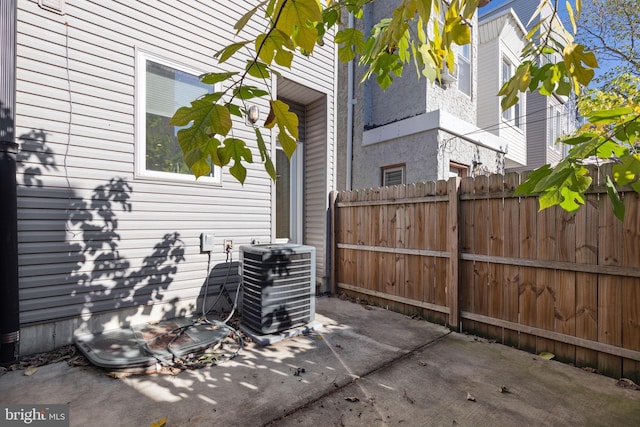 view of patio with central AC unit and fence