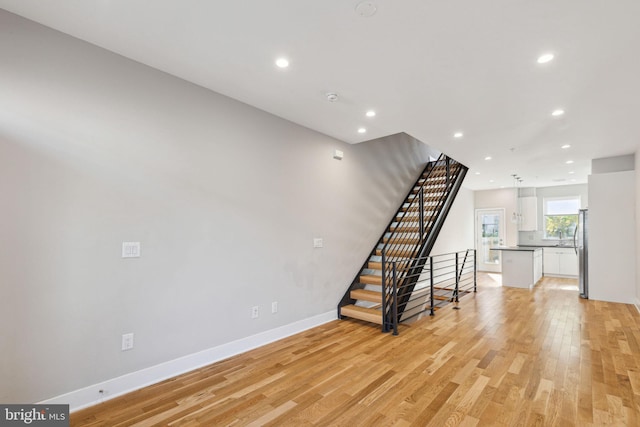 interior space with recessed lighting, baseboards, stairs, and light wood finished floors