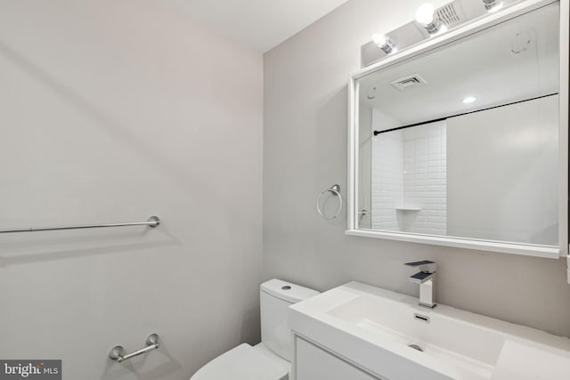 bathroom featuring vanity, toilet, and visible vents