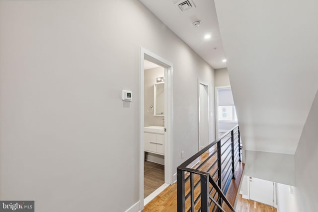 corridor with recessed lighting, baseboards, visible vents, and light wood finished floors