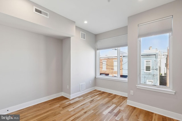 spare room with visible vents, baseboards, and light wood-style floors