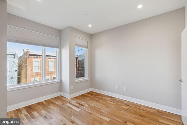 empty room featuring recessed lighting, light wood-type flooring, and baseboards