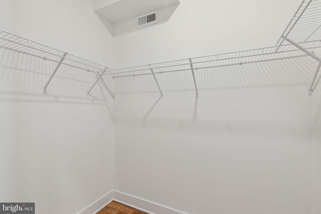 spacious closet featuring wood finished floors and visible vents