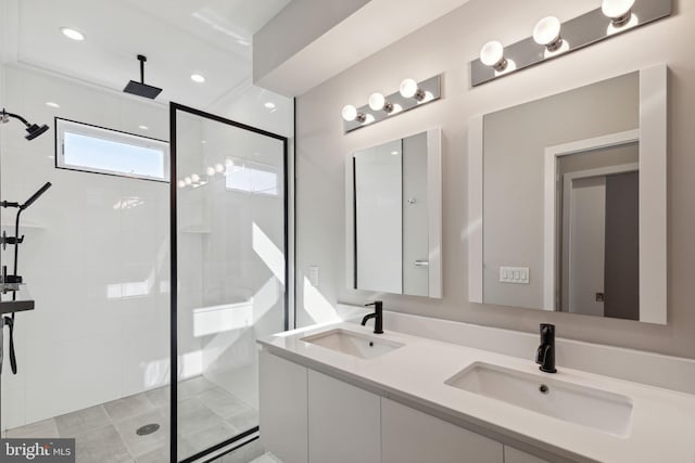 bathroom featuring a sink, tiled shower, and double vanity