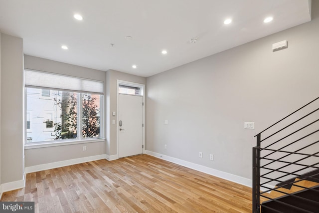 entrance foyer featuring recessed lighting, light wood-style flooring, stairs, and baseboards