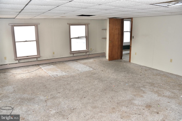 spare room with a baseboard heating unit, a paneled ceiling, and a healthy amount of sunlight