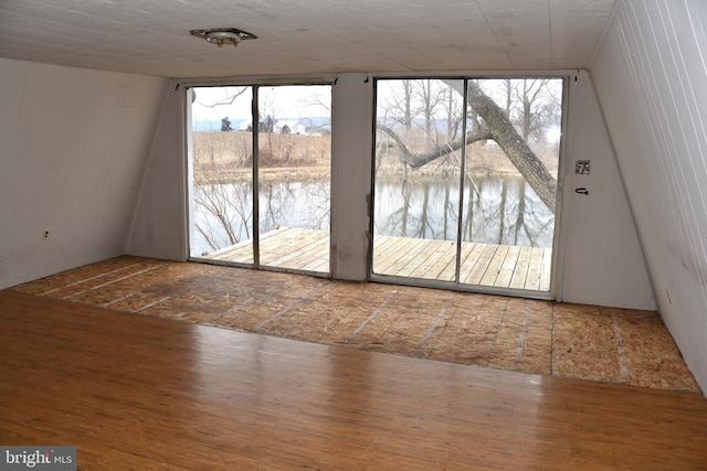 doorway featuring plenty of natural light, a water view, and wood finished floors