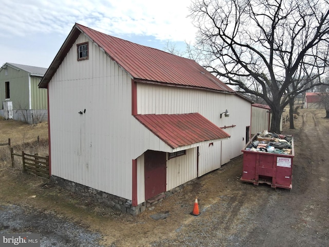 view of outbuilding featuring fence and an outbuilding