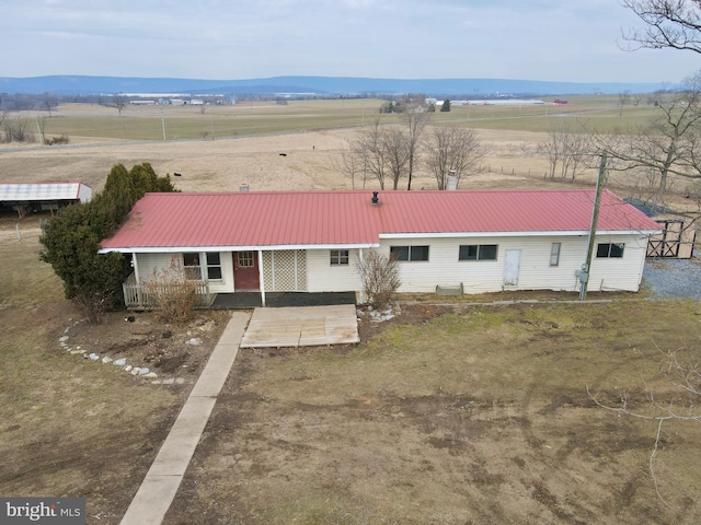 view of front of house featuring metal roof, a porch, and a rural view