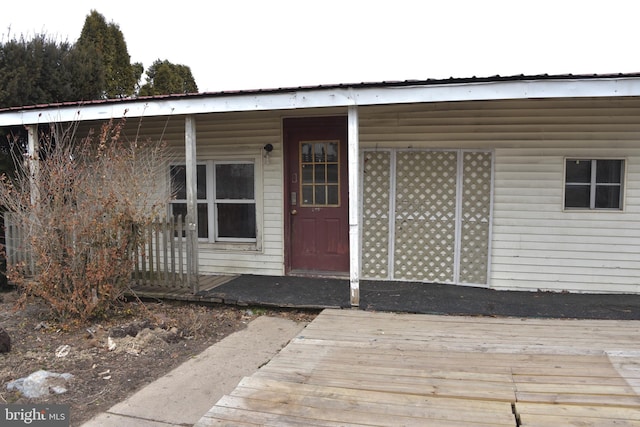 entrance to property featuring covered porch and metal roof