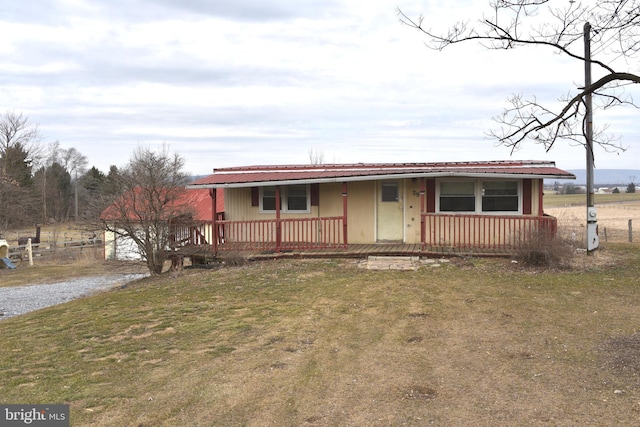 view of front of house with metal roof, a porch, and a front yard